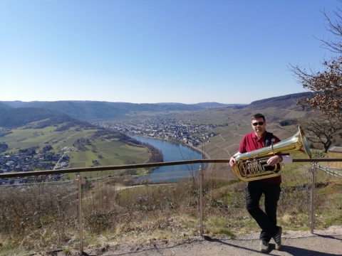 Oliver mit der Tuba vor dem sonnigen Kröver Moseltal